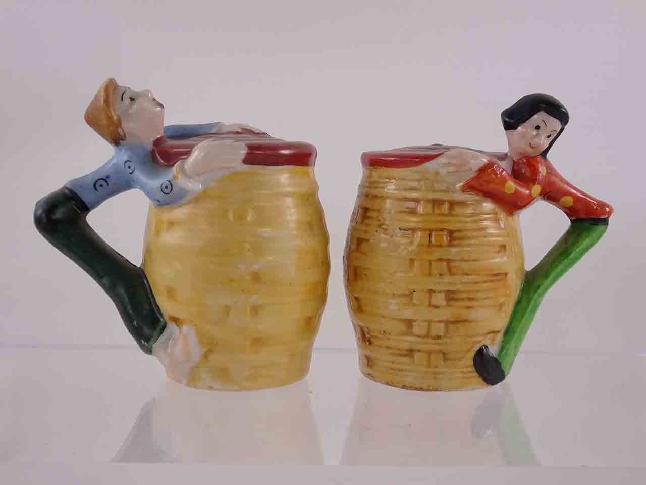 53981 People hanging off sides of baskets salt and pepper shakers