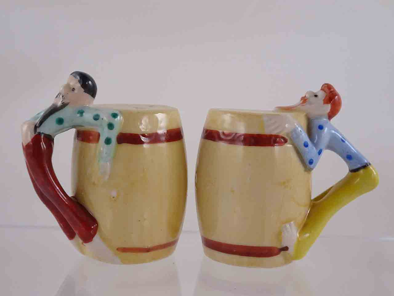 53982 People hanging off sides of barrels salt and pepper shakers